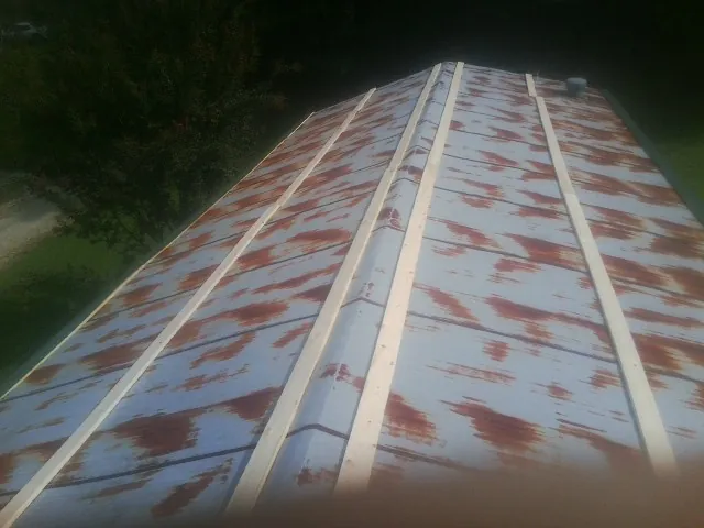 Rusted metal roof panels with new wood purlins before replacement — Storm Damage Roof Repair in Connellsville by Roofing Brothers