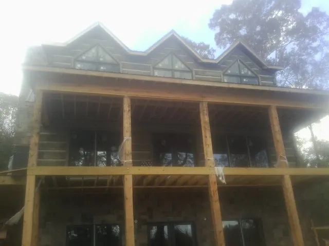 Dormers and porch framing on a large log home under construction — Roof Coating work by our crew in Connellsville