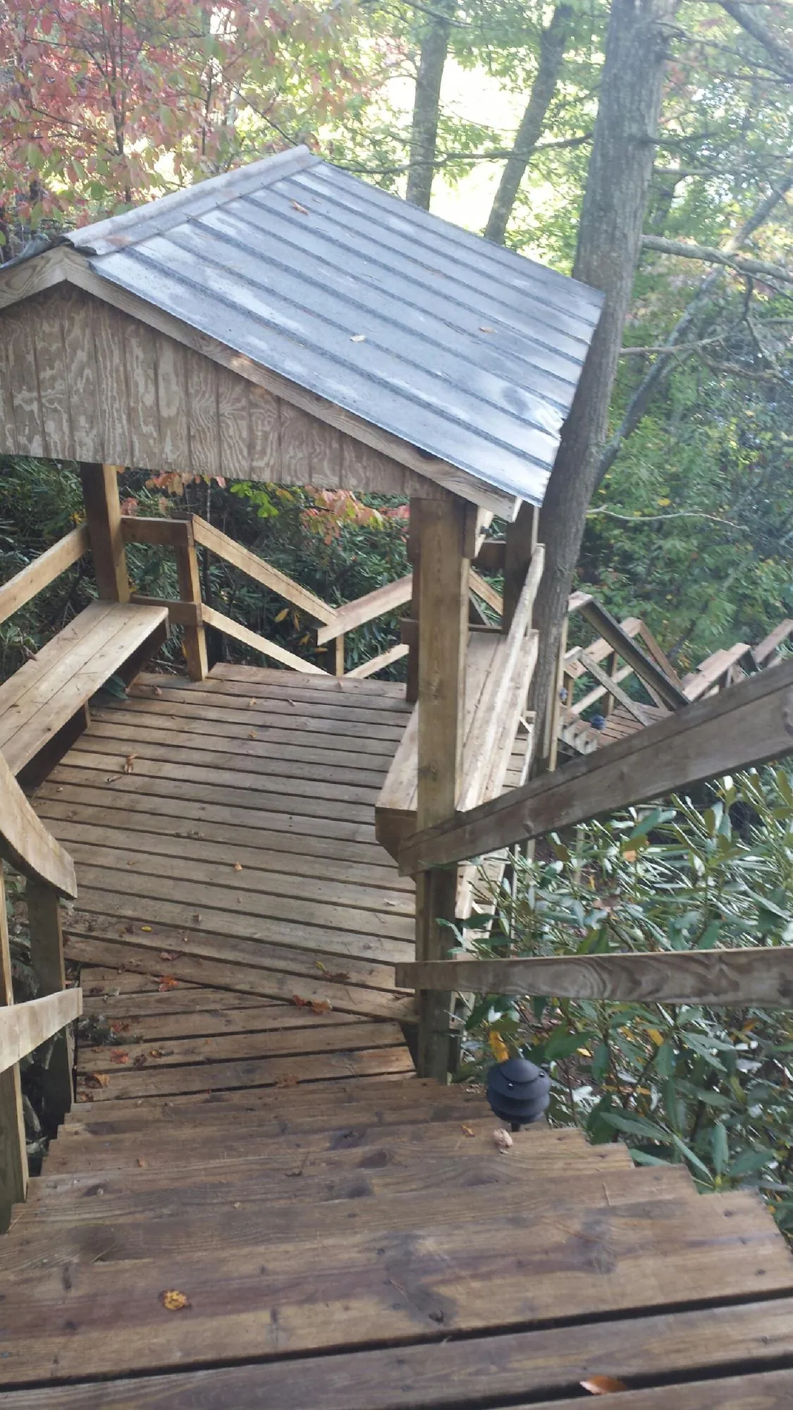 Metal roofed shelter over wooden steps on a wooded walkway — Skylight Repair & Installation work by our crew in Connellsville
